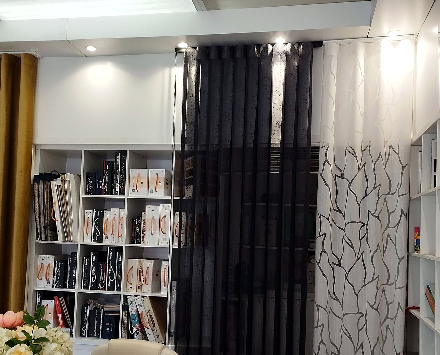 Tende su misura nere e bianche nello showroom con libreria
